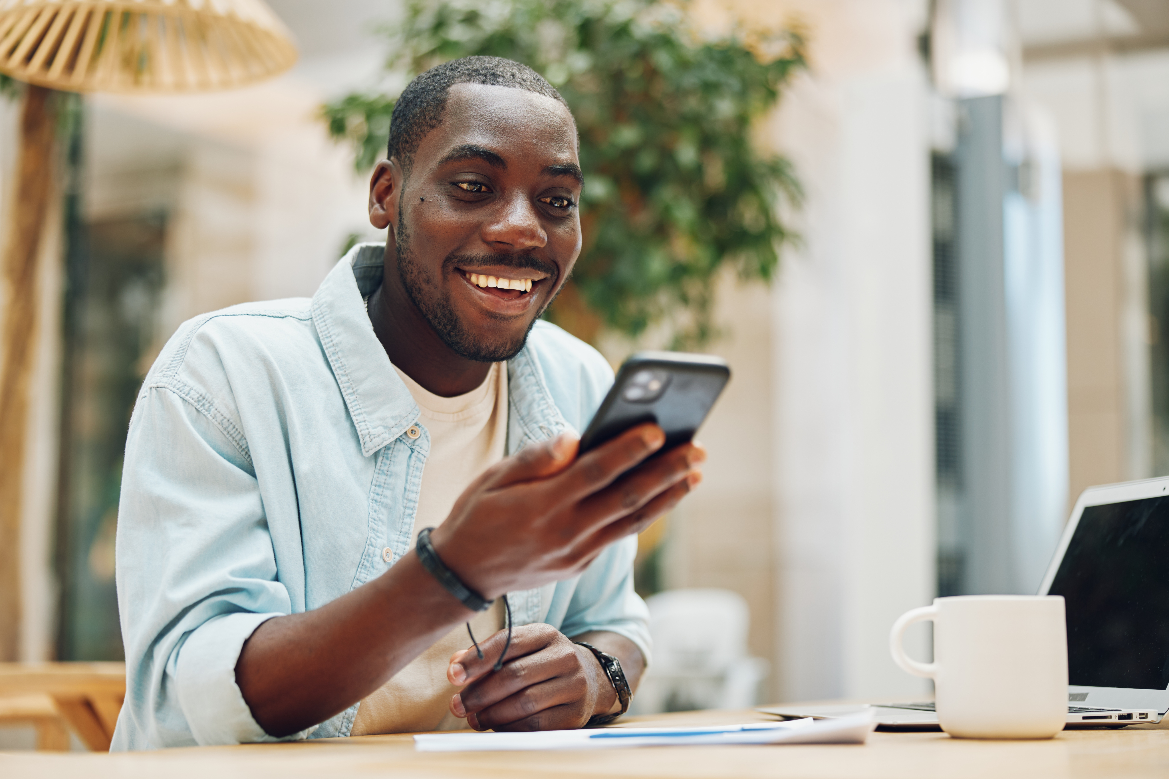 Man in a blue shirt looking at his smartphone screen